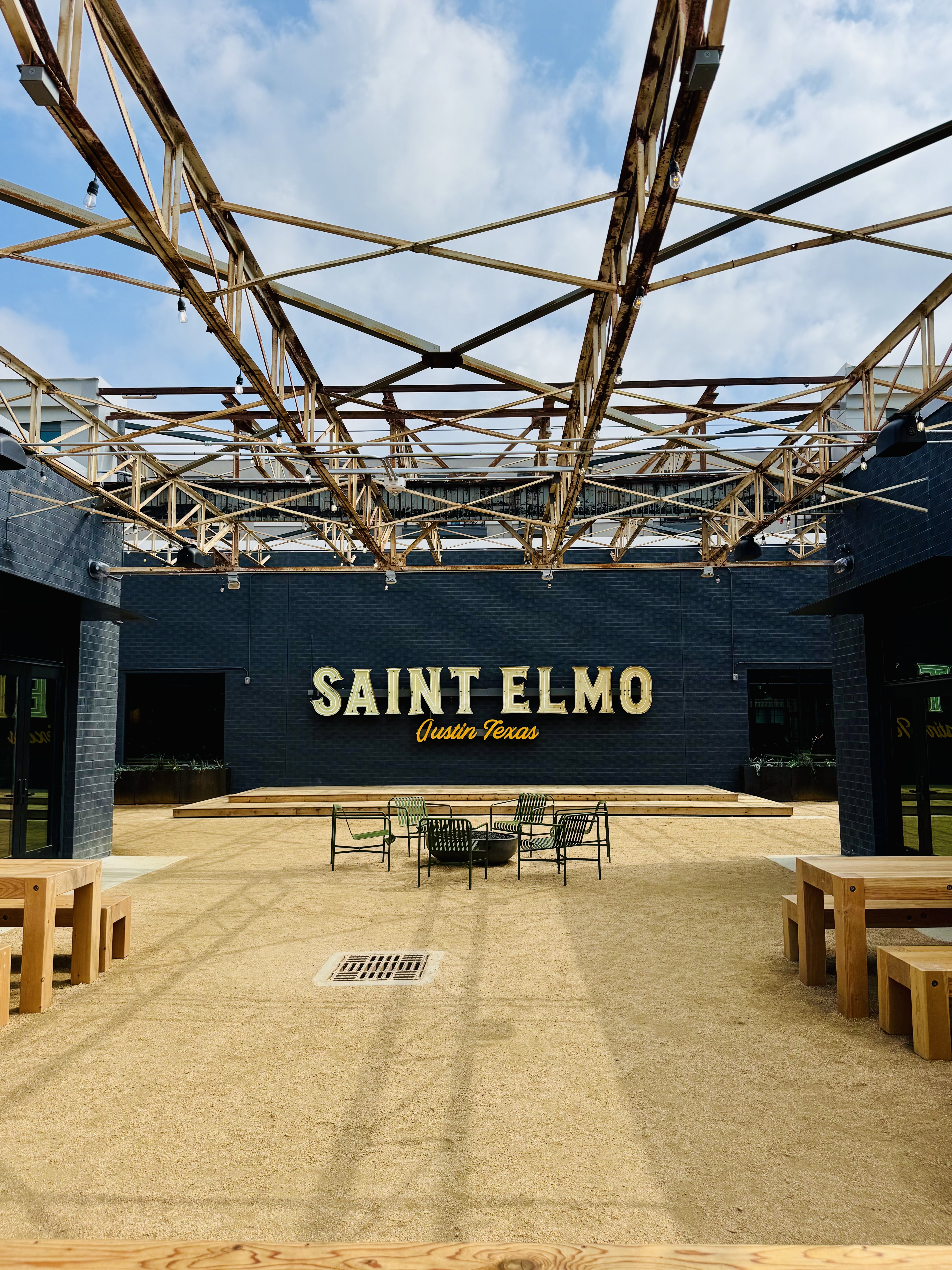 The Saint Elmo courtyard — salvaged steel trusses over a decomposed granite court